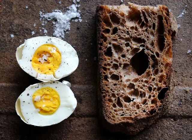 Egg. One boiled egg with wholemeal bread on a rusty background.