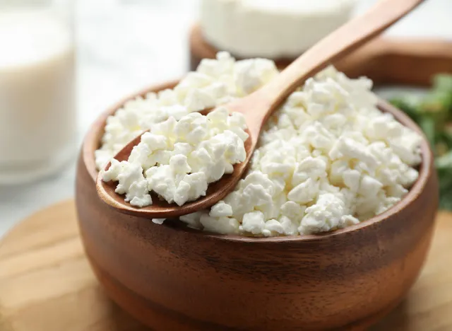 Delicious fresh cottage cheese in bowl on table, closeup