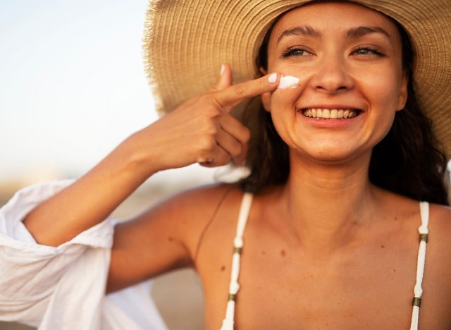 Woman using sunscreen cream. Beautiful girl with sun protection cream.