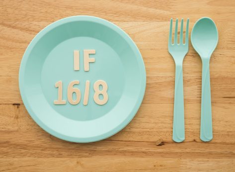 IF (Intermittent Fasting) 16 and 8 diet rule and weight loss concept. Flat lay IF 16 and 8 letter on blue plate, spoon and fork on wooden table background.