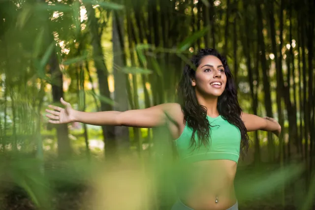 Woman,Stretching,Her,Arms,In,Bamboo,Garden