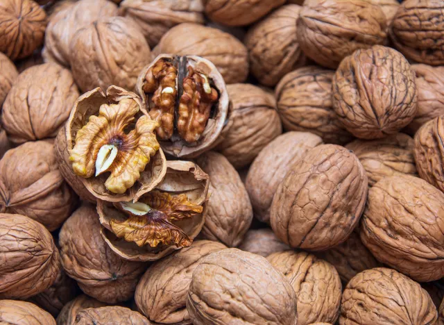 Cracked walnuts on a background covered with walnuts