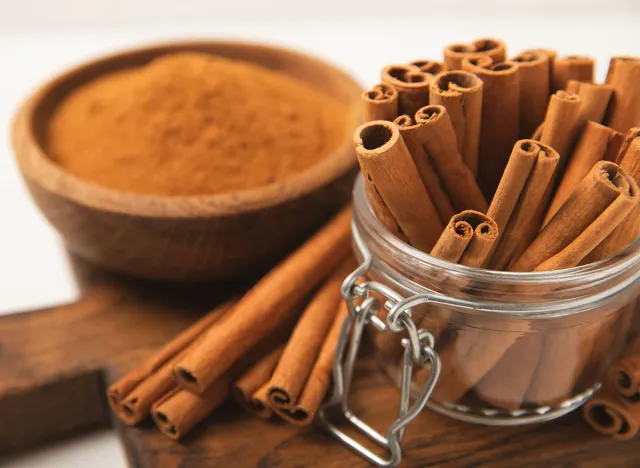 Cinnamon sticks on a textured wooden background. Cinnamon roll. Spicy spice for baking, desserts and drinks. Fragrant ground cinnamon. cinnamon powder Close-up. Place for text. copy space