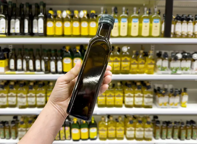 choosing olive oil, sauce, vinegar at the grocery store