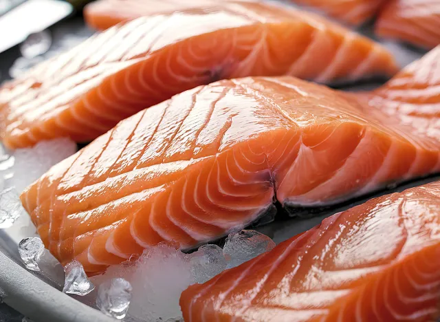 An enticing close-up image of fresh, glistening raw salmon fillets artfully arranged on a bed of ice