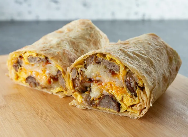 A view of a breakfast burrito, featuring sausage links.