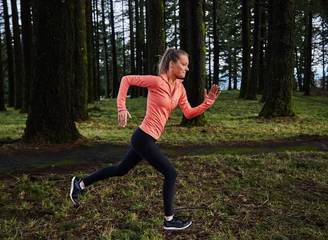 girl running in formation in forest in pink shirt