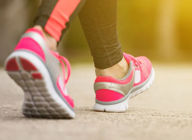 Fitness woman training and jogging in summer park, close up on running shoes in sunlight. Healthy lifestyle and sport concept