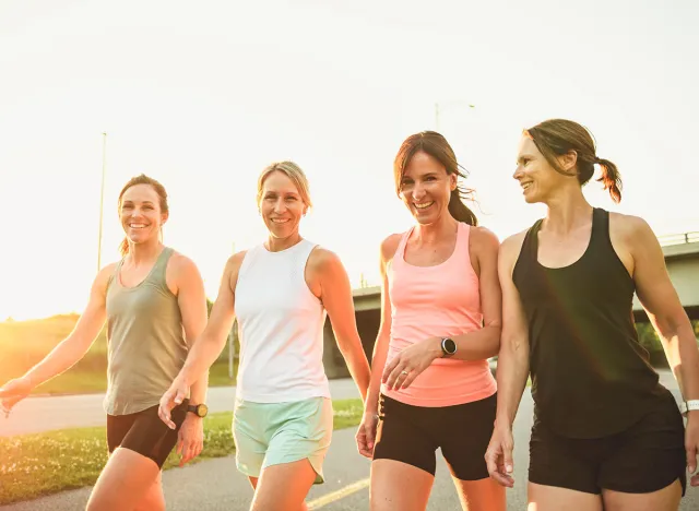 The females in sportswear walking together bright sunny park in summer