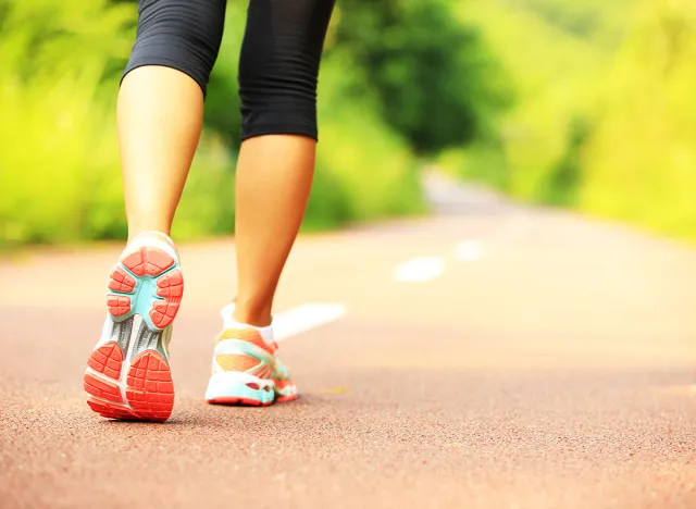 young fitness woman hiker legs at forest trail