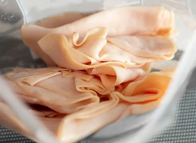 A view looking into a package of processed turkey deli meat slices.