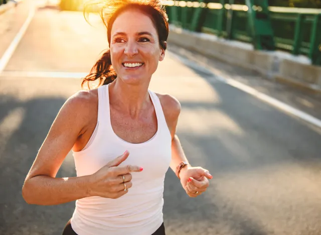 A great sporty woman jogging outdoors on sunset time