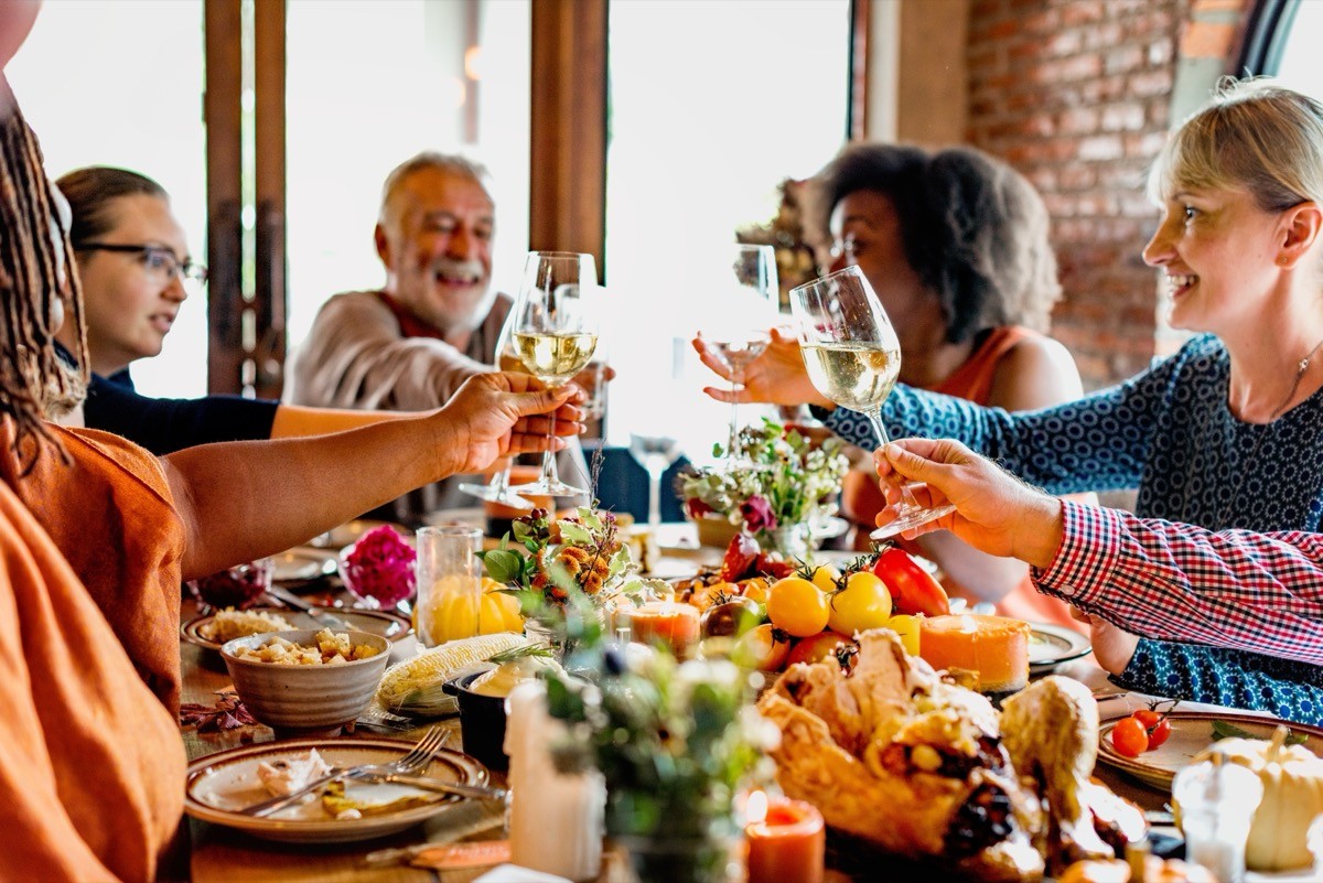 Diverse,Group,Enjoying,A,Festive,Meal,,Toasting,With,Wine.,Celebrating