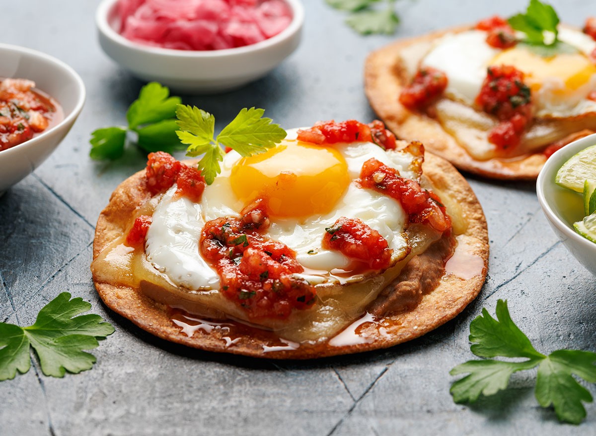 Huevos Rancheros tostadas with fried egg, tomato salsa, bean paste and cheese. Mexican food