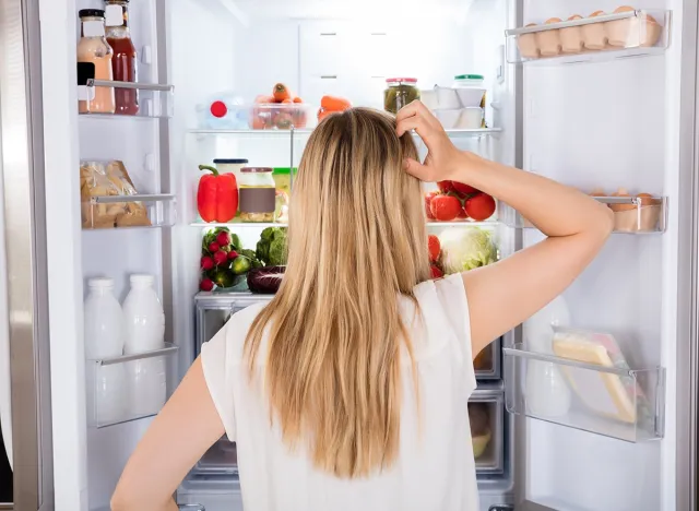 Rear View Of Young Woman Looking In Fridge At Kitchen, hunger