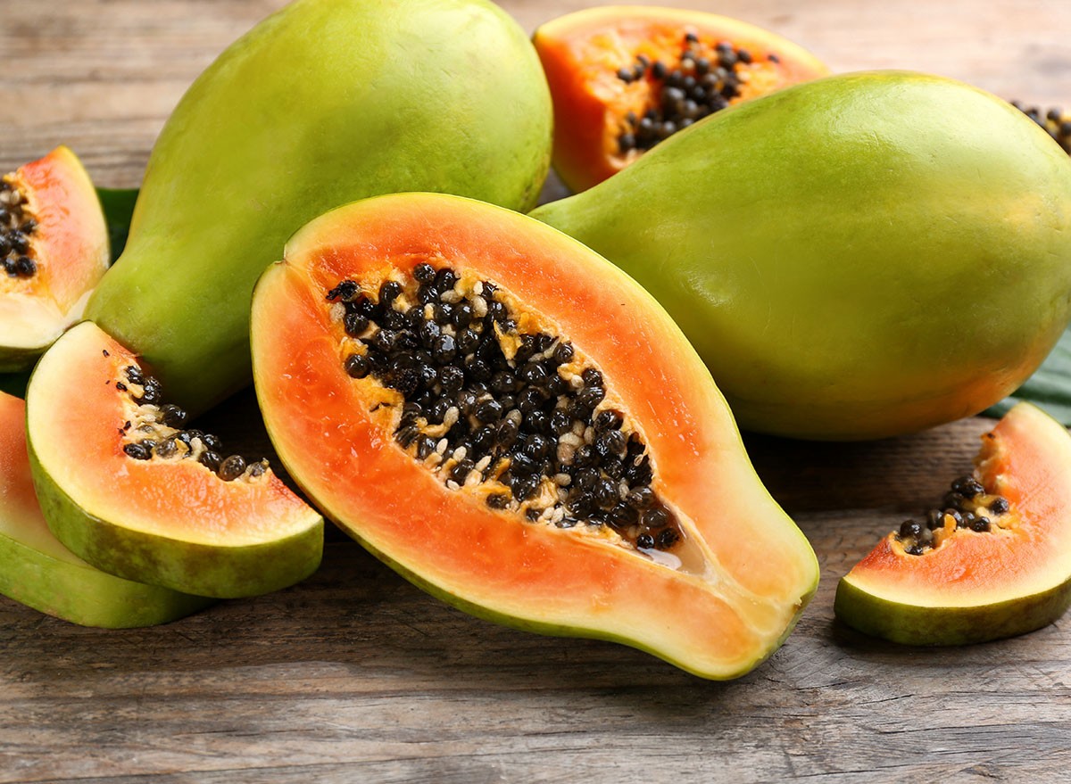 Fresh ripe papaya fruits on wooden table, closeup