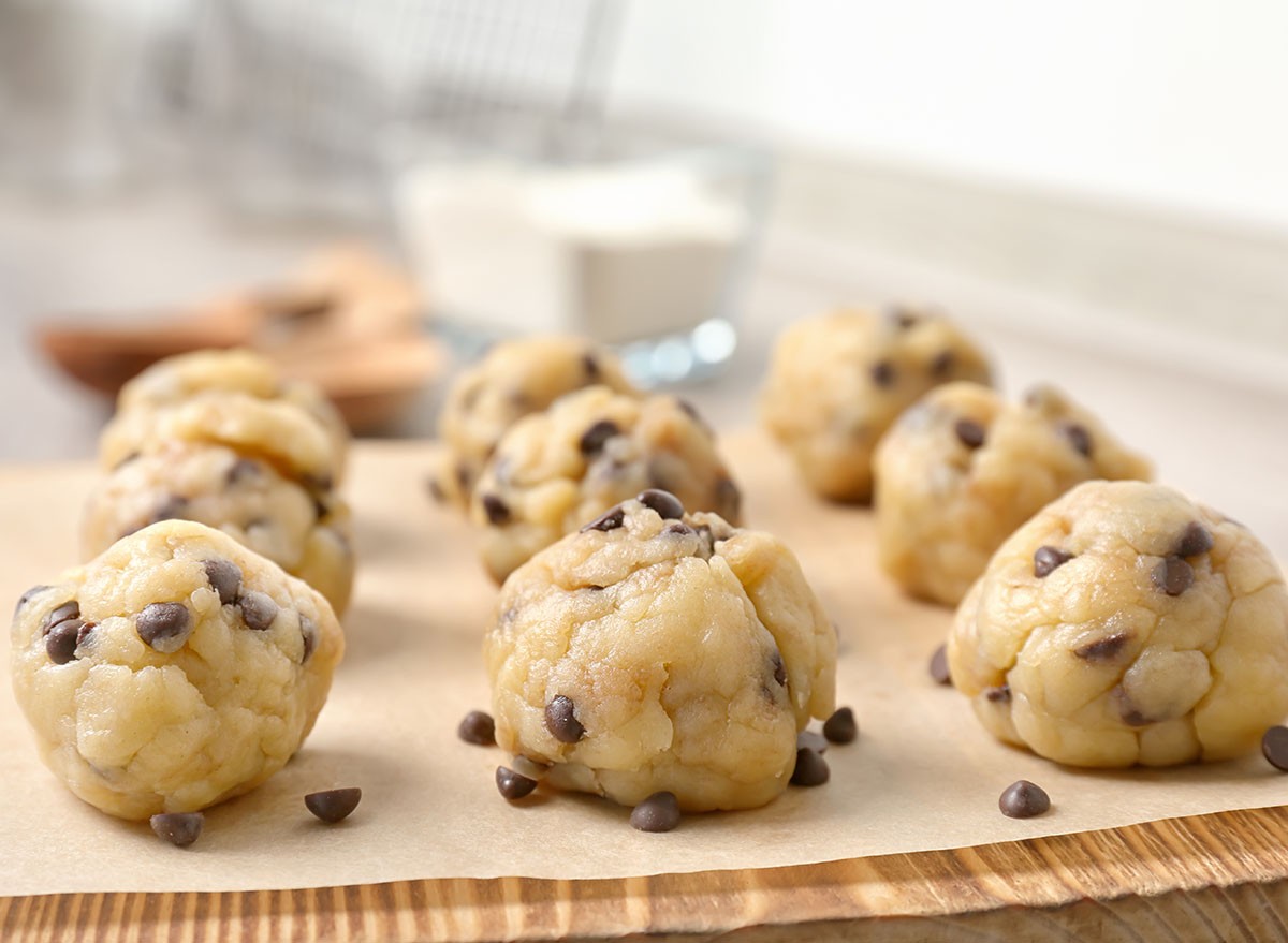 Raw cookie dough with chocolate chips on wooden board