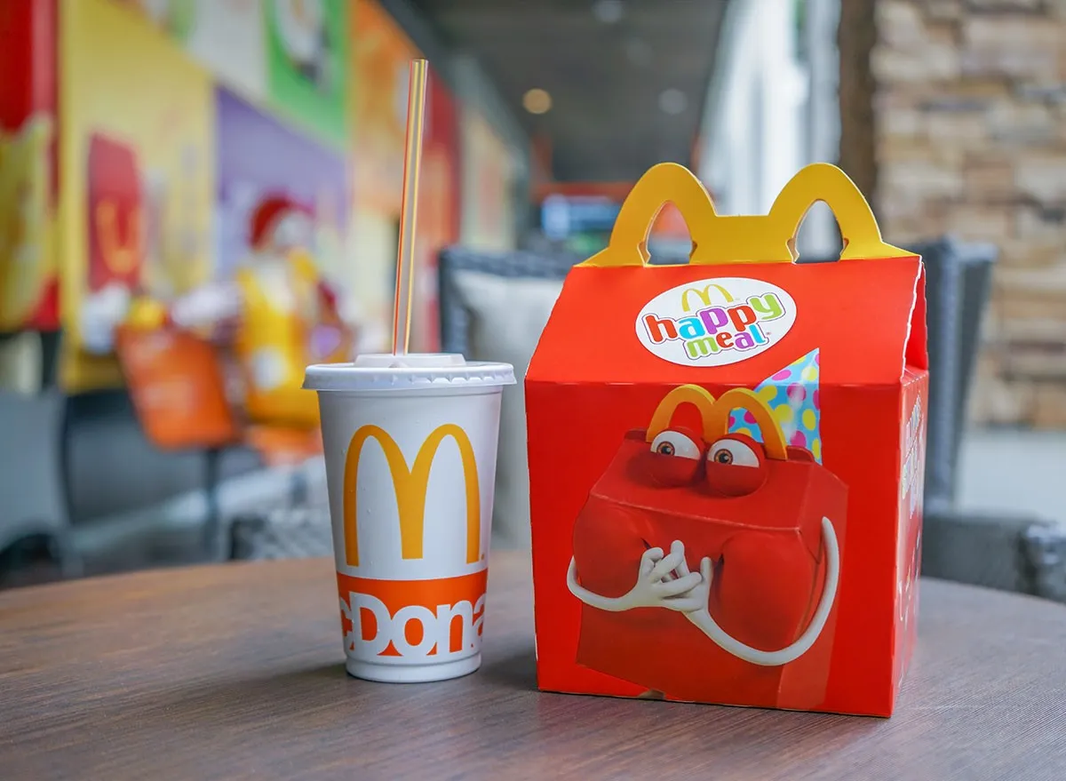 Happy meal set ,in soft focus, with blurred Ronald Mcdonald at McDonald's restaurant o