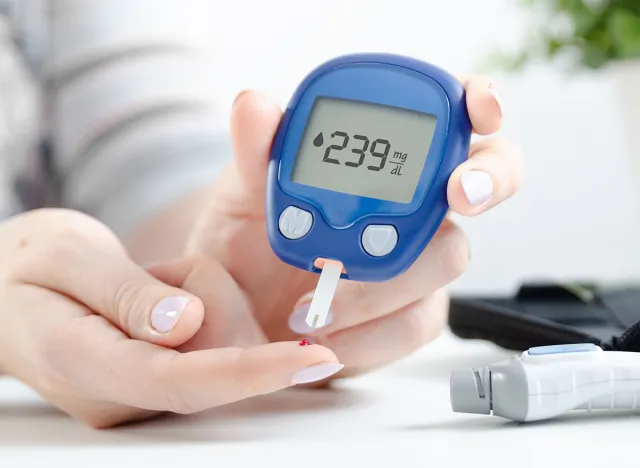 Woman use glucometer checking blood sugar level
