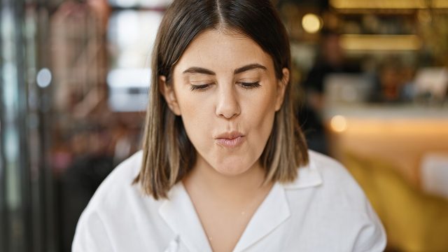 Young beautiful hispanic woman eating at the restaurant
