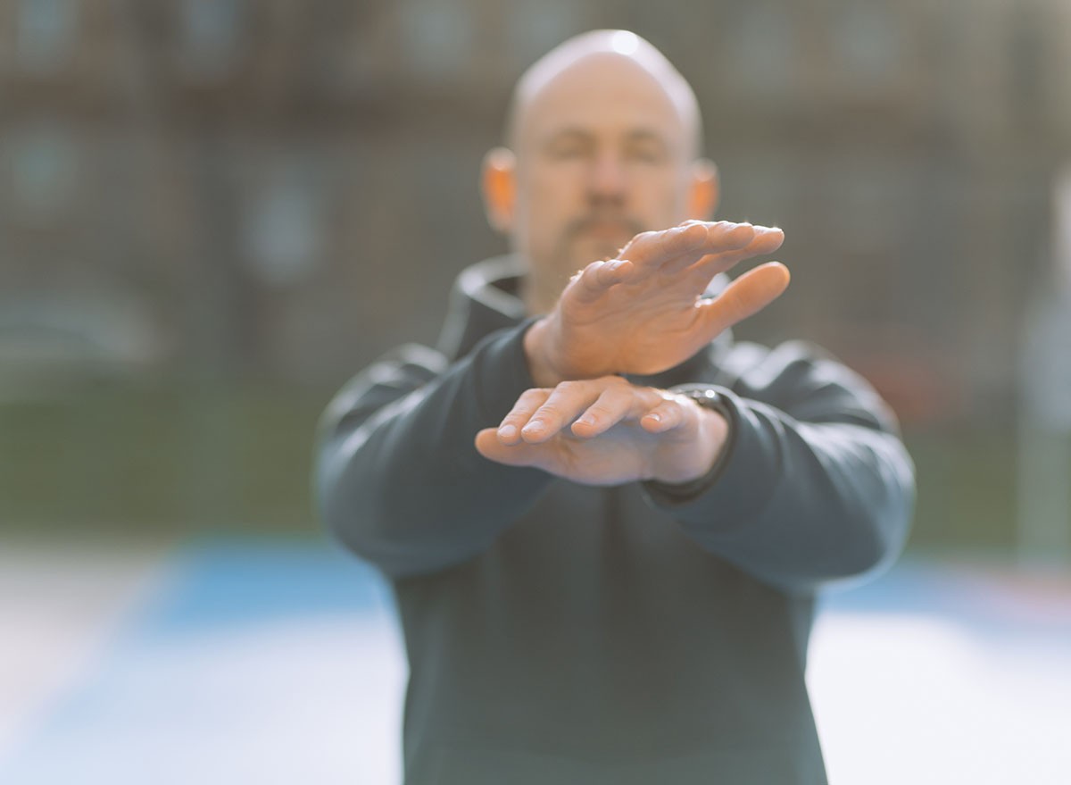 a man does an exercise with his knees. the boy does sports. Crisscross Arms, scissors
