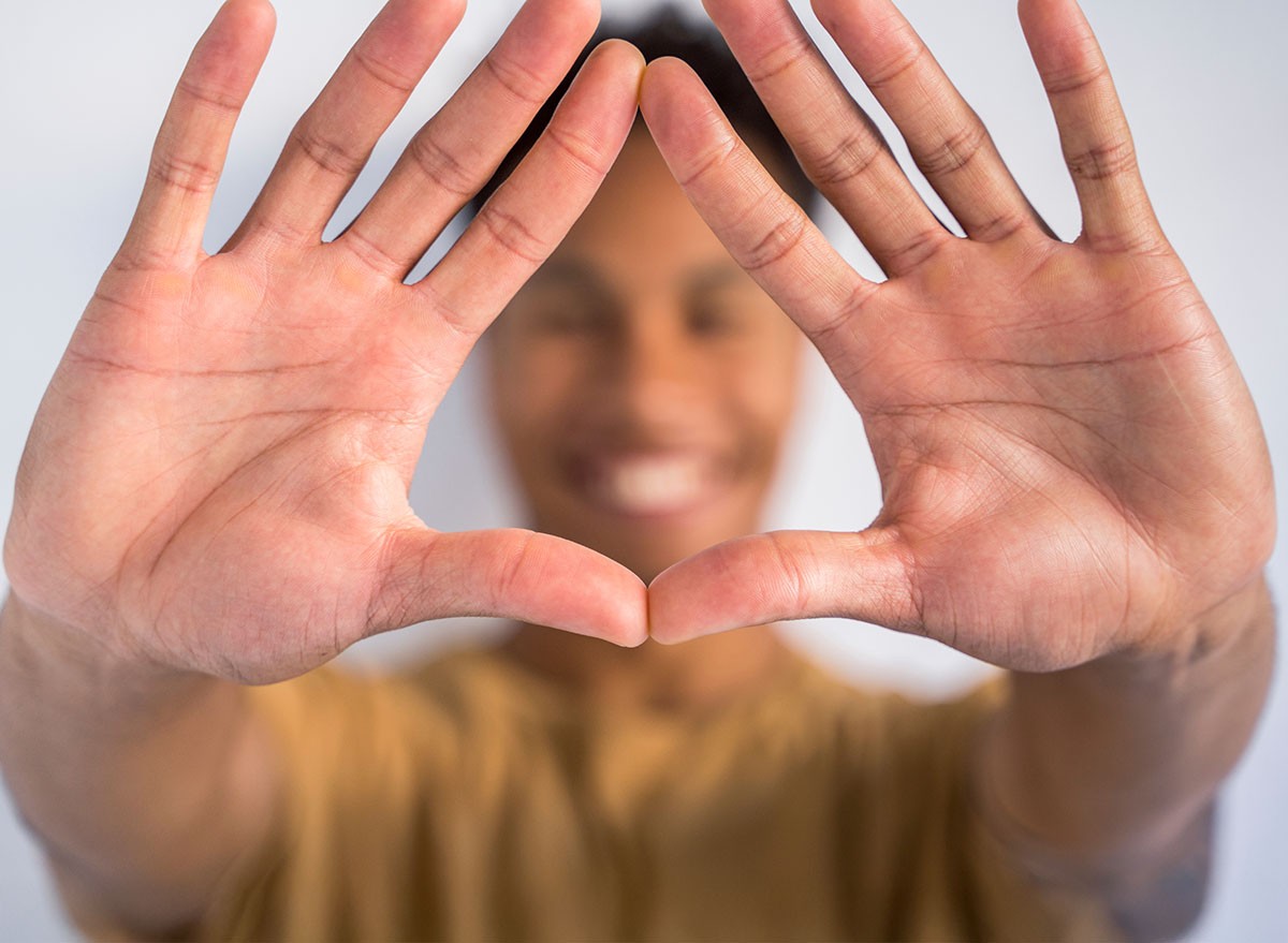 Detail of wide open hands together in the front. Unrecognizable african american man doing a triangle sign shape with the hands. Stop racism and embrace different ethnics. Afro culture lifestyle. Prayer Push Out