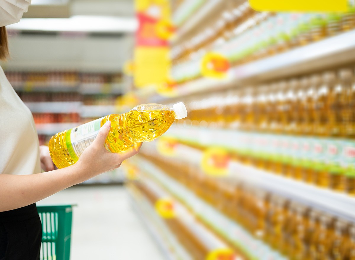 Woman,Buying,Cooking,Oil,In,Supermarket,canola,olive,