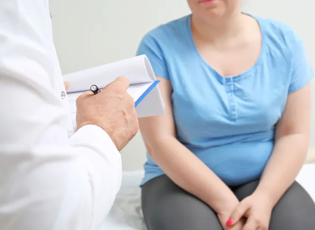 Overweight woman discussing test results with doctor in hospital