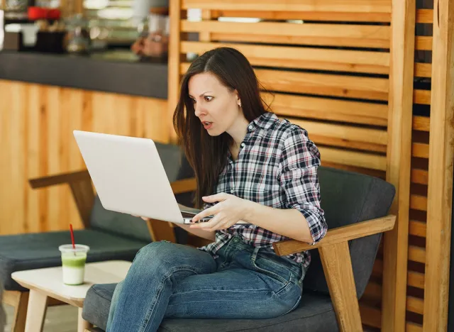 Angry screaming sad upset girl in outdoors street coffee shop wooden cafe sitting with modern laptop pc computer, disturb problem during free time. Mobile Office. Lifestyle freelance business concept