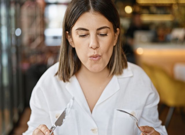 Young beautiful hispanic woman eating at the restaurant