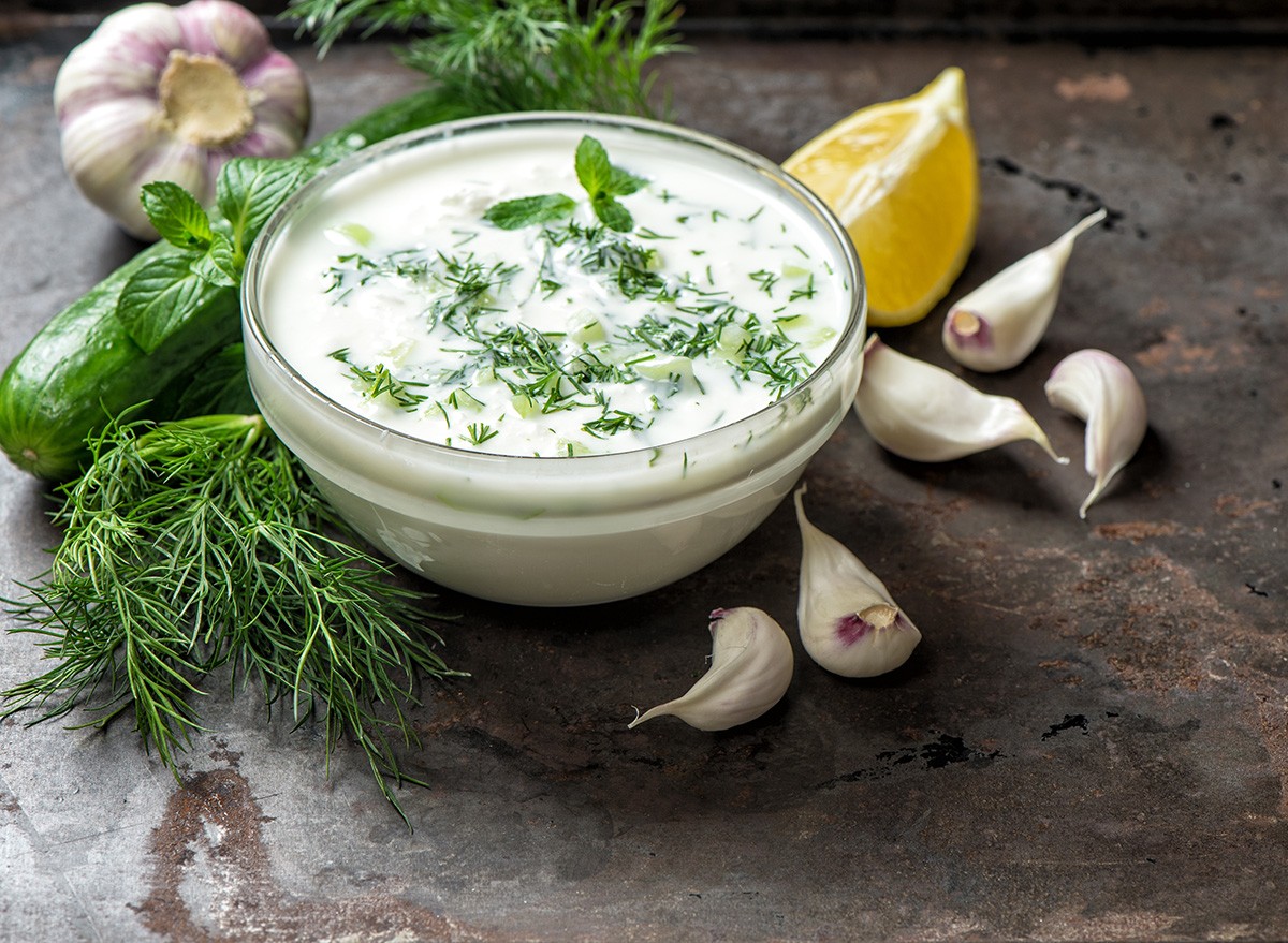 Tzatziki sauce with ingredients cucumber, garlic, dill, lemon, mint. Healthy food background
