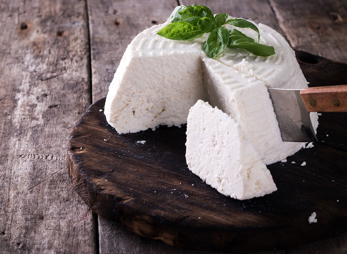A fresh ricotta with basil leaf on wooden table italian food concept