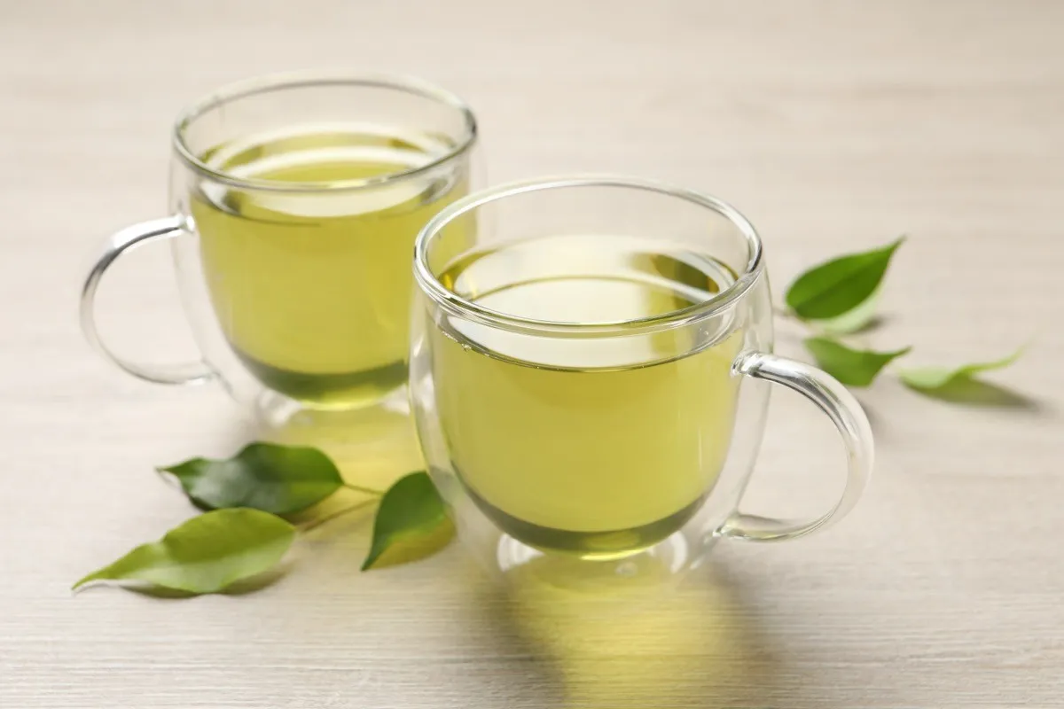 Refreshing,Green,Tea,In,Cups,And,Leaves,On,Wooden,Table,