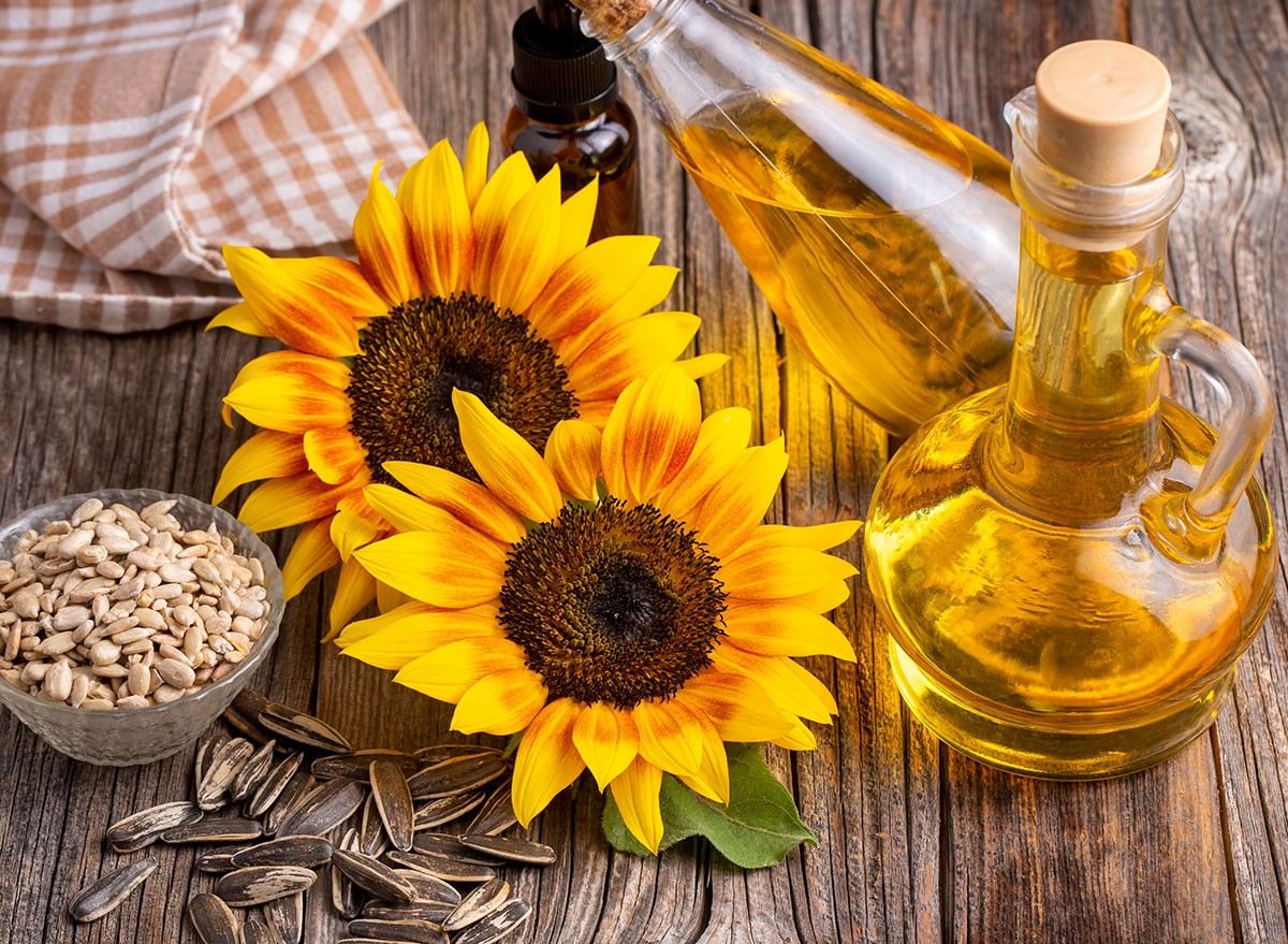 Sunflower and sunflower oil on the wooden background
