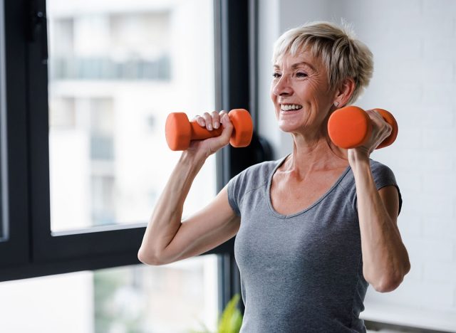 Portrait of senior woman lifting dumbbells, mature