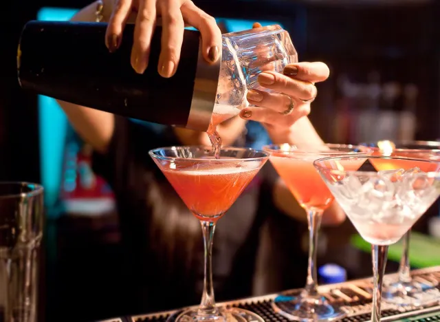 The girl bartender prepares a cocktail in the nightclub. Alcohol
