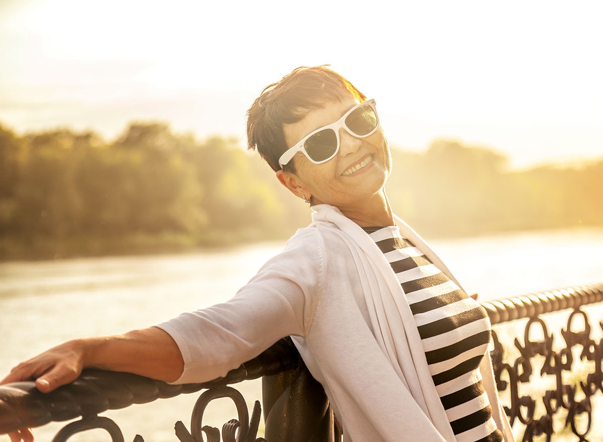 Portrait of a happy attractive mature senior woman 50 years old at sunset