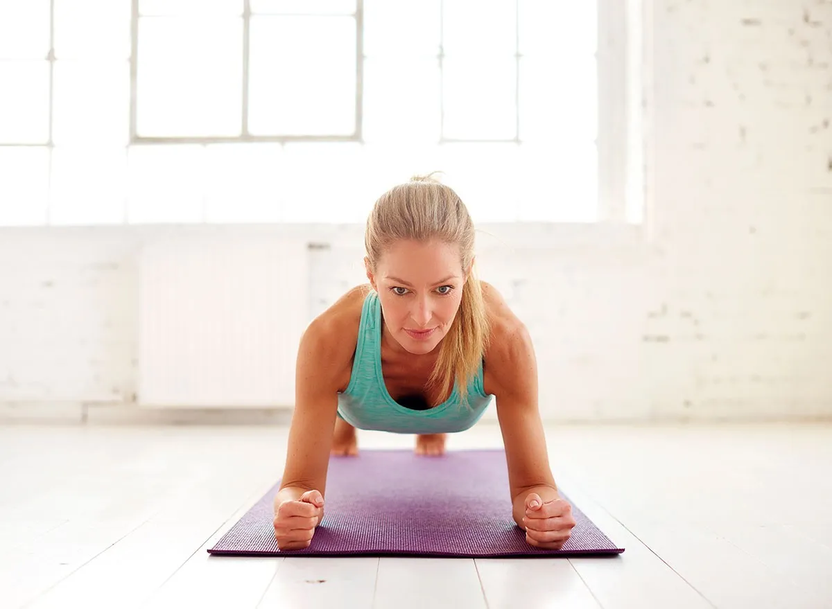 Sphinx Push-Ups, Portrait shot of attractive middle aged woman doing plank exercises on yoga mat in the fitness studio.