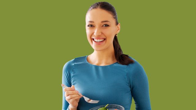 Fit woman eating healthy salad.