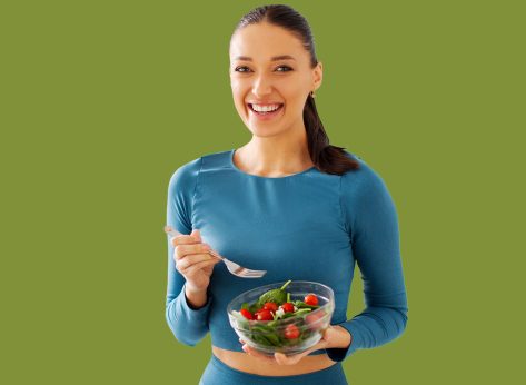 Fit woman eating healthy salad.
