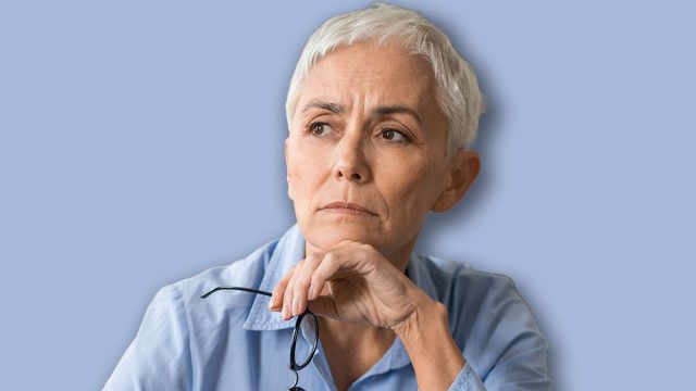 Mature woman holding glasses and thinking