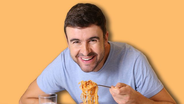 Man enjoying a plate of spaghetti with tomato sauce