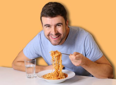 Man enjoying a plate of spaghetti with tomato sauce