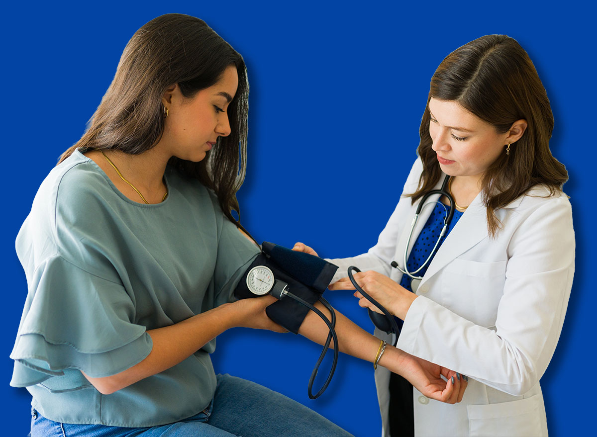 Young female patient having her blood pressure checked by a doctor during a medical examination