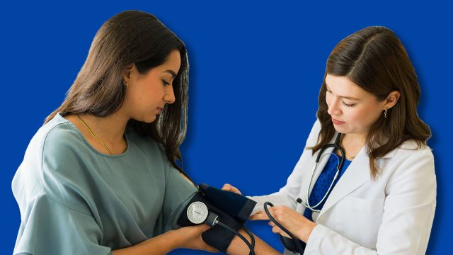 Young female patient having her blood pressure checked by a doctor during a medical examination