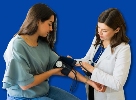 Young female patient having her blood pressure checked by a doctor during a medical examination