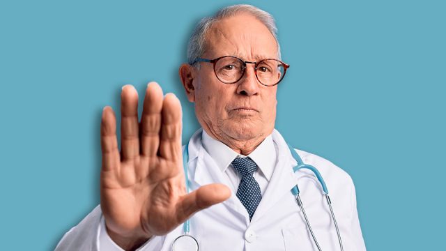Senior grey haired doctor man wearing stethoscope and medical coat over blue background doing stop sing with palm of the hand. Warning expression with negative and serious gesture on the face.