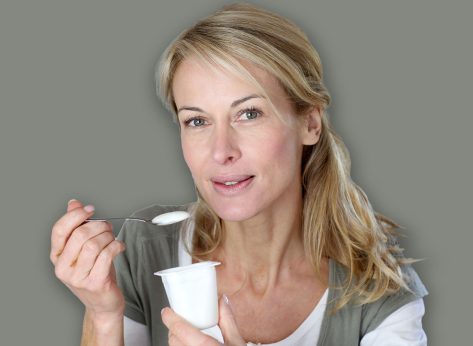 Portrait of middle-aged woman eating yoghurt