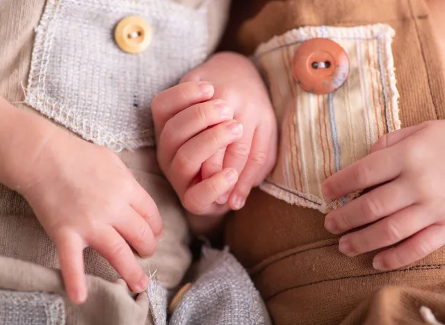 Twin babies Little newborn human baby hands holding each other
