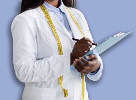 Cheerful black nutritionist with clipboard prescribing healthy diet or creating plant based meal plan for patient at weight loss clinic, copy space